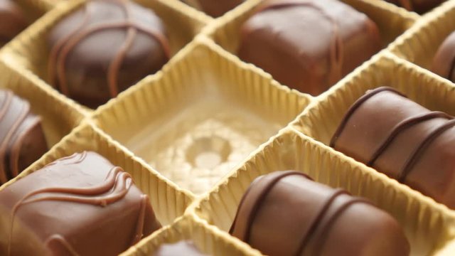 Female hand over luxurious set of many different sweets 4K 2160p 30fps UltraHD footage - Woman picking one piece from assorted chocolate box 3840X2160 UHD video 