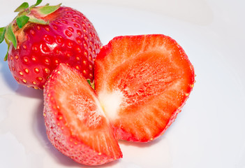 red strawberries closeup on white dish, background