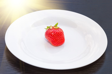 ripe strawberries on a white plate, background