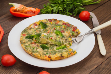 Spanish tortilla on a white plate. Restaurant supply. Wooden rustic table. Top view