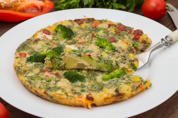Spanish tortilla on a white plate. Restaurant supply. Wooden rustic table. Top view