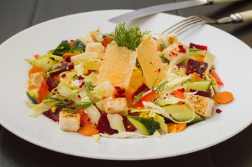 Vegetarian salad with vegetables and cheese crisps. Wooden table. Close-up