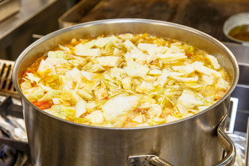 The soup is cooked in a large pot in the kitchen in the restaura