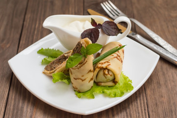 Pancakes with a liver on wooden table. Restaurant supply. Top view. Close-up