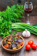 Roasted meat with potatoes, ojaxuri, hot in Georgian and red wine on a wooden table. Top view. Close-up