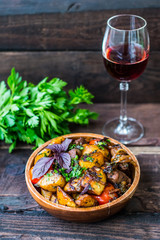 Roasted meat with potatoes, ojaxuri, hot in Georgian and red wine on a wooden table. Top view. Close-up