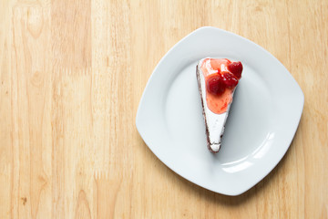 Strawberry cake with white plate on wooden background