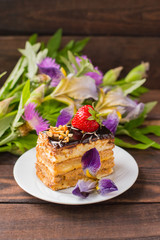 Fresh cream cake slice on a wooden table. Top view. Close-up