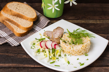 Rice porridge with homemade sausage and salad  radish. Wooden table. Top view. Close-up