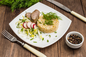 Rice porridge with homemade sausage and salad  radish. Wooden table. Top view. Close-up