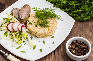 Rice porridge with homemade sausage and salad  radish. Wooden table. Top view. Close-up