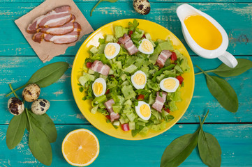 Salad with spinach, quail eggs and bacon. Wooden table. Top view