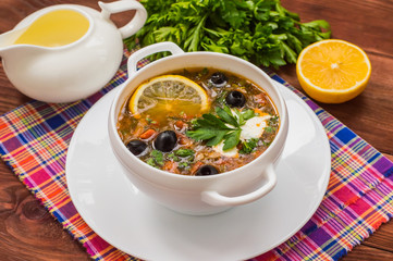 Solyanka, Russian dishes, soup on a steep meat broth with hot spices. Wooden background
