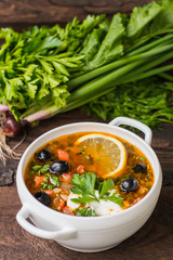 Solyanka, Russian dishes, soup on a steep meat broth with hot spices. Wooden background. Top view