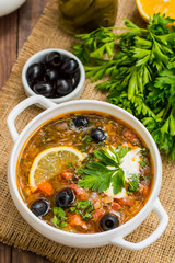 Solyanka, Russian dishes, soup on a steep meat broth with hot spices. Wooden background. Top view