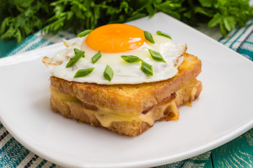 Croque-Madame, a French sandwich with greens and berry juice for breakfast. Wooden table. Top view. Close-up