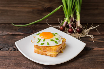 Croque-Madame, a French sandwich with greens and berry juice for breakfast. Wooden table. Top view. Close-up
