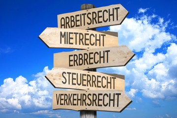 Wooden signpost - law concept - "Arbeitsrecht, Mietrecht, Erbrecht, Stuerrecht, Verkehrsrecht" (German) - "Employment, rent, inheritance, fiscal, traffic law" (English).