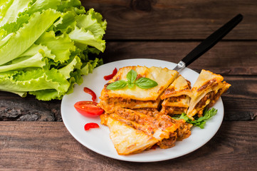 Lasagna, traditional Italian food on a wooden background