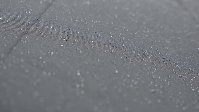 Shallow DOF black waterproof fabric surface 4K 2160p 30fps UHD footage - Rain drops covering top of dark protective umbrella 3840X2160 UltraHD video