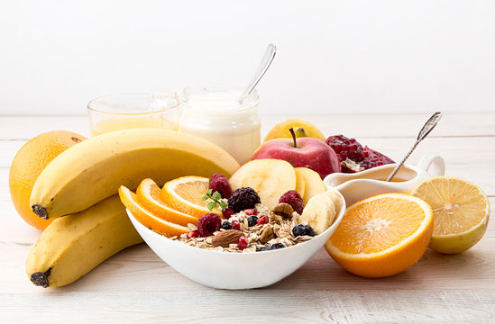 Healthy breakfast. Muesli, yogurt, honey and fruits on white tab