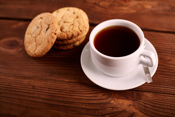 Coffee and Homemade cookies with chocolate. Handmade Chocolate cookies and cup of espresso on wooden table. Pile of delicious chip cookies. Christmas cookies. Biscuits. Oat biscuits.