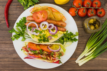 Ingredients for a picnic consisting of vegetables and sausages grilled on wooden rustic background, top view. Close-up