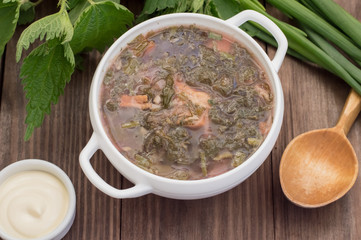 Borsch from a nettle on  wooden table. Top view