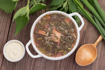 Borsch from a nettle on  wooden table. Top view