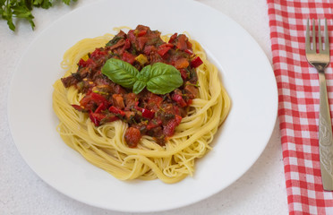 Italian pasta with tomatoes, capsicum and beef tongue on a white table