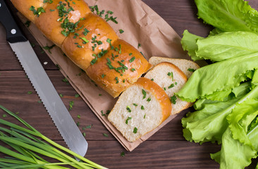 Garlic bread with cheese and herbs on a wooden background. Top view. Close-up