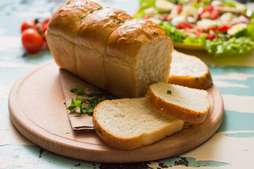 Garlic bread with salad and cherry tomatoes on wooden background. Top view. Close-up