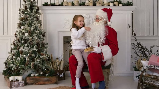 Surprised little girl checking upon Santa beard