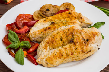 Chicken fillet grilled with vegetables. Wooden background. Top view
