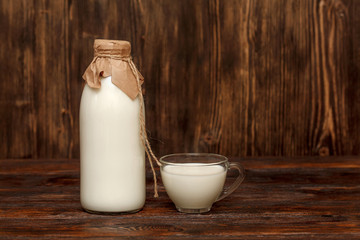 Bottle of milk and cup on rustic wooden table