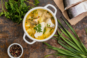 Fresh fish soup with ingredients and spices for cooking. Wooden background. Top view. Close-up