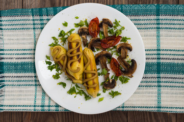 Zrazy Potato stuffed with meat  mushrooms and grilled tomatoes on a white plate. Wooden background. Top view. Close-up