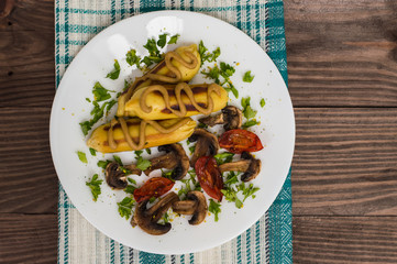 Zrazy Potato stuffed with meat  mushrooms and grilled tomatoes on a white plate. Wooden background. Top view. Close-up