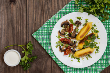 Zrazy Potato stuffed with meat  mushrooms and grilled tomatoes on a white plate. Wooden background. Top view. Close-up