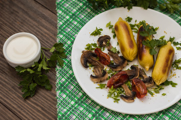 Zrazy Potato stuffed with meat  mushrooms and grilled tomatoes on a white plate. Wooden background. Top view. Close-up