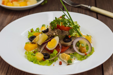 Salad with tongue on the wooden background