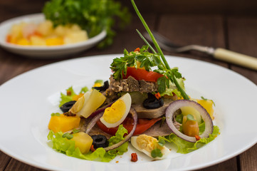 Salad with tongue on the wooden background