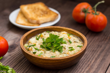 Wheat porridge with meat prepared on a fire in  wooden plate   rustic table. Top view