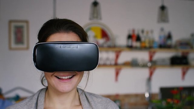 4K Portrait of a young woman using Virtual reality headset in her home, with space for text - version 2
