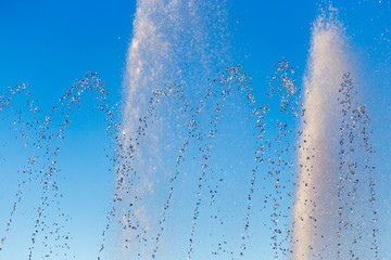Naklejka na ściany i meble water splashing from the fountain in the background of blue sky