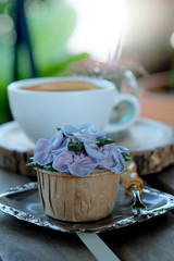 Blue cupcake design cream like blue Hydrangea flower Served with hot black coffee on wooden table background and have some space for write wording