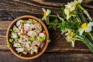 Salad with radishes, apples and greens. Wooden background. Top view. Close-up