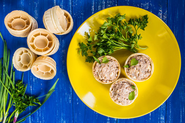 Tartlets with pate of fish and greens on a wooden blue background. Top view. Close-up