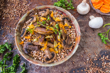 Buckwheat porridge with meat and mushrooms on the old table. Top view. Close-up