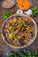 Buckwheat porridge with meat and mushrooms on the old table. Top view. Close-up